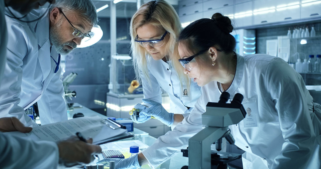 Team of Medical Research Scientists Work on a New Generation Disease Cure. They use Microscope, Test Tubes, Data Implementing Technology. Laboratory Looks Busy, Bright and Modern.