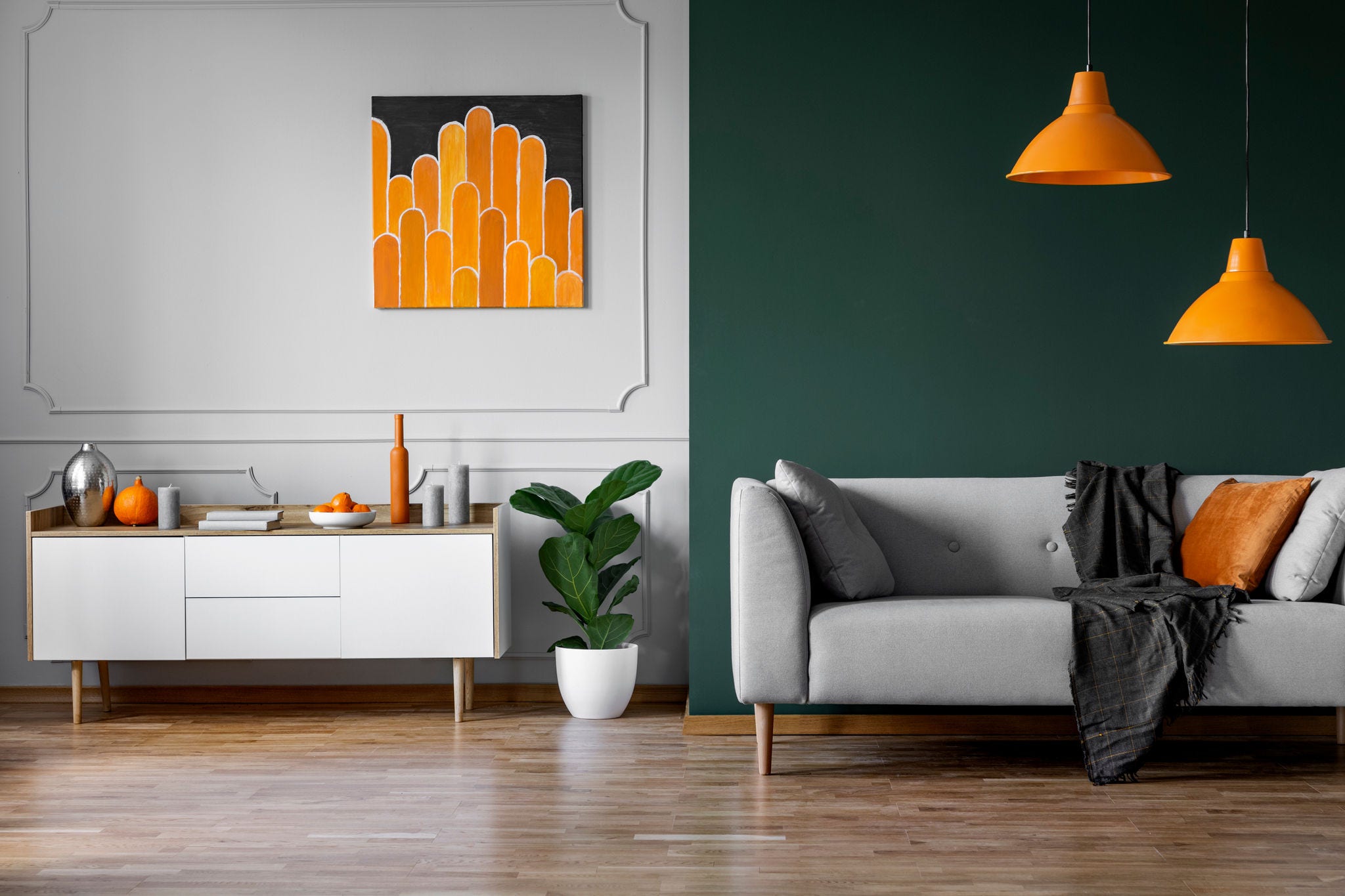 Parede verde e cinza do interior da elegante sala de estar com móveis de madeira branca e sofá cinza