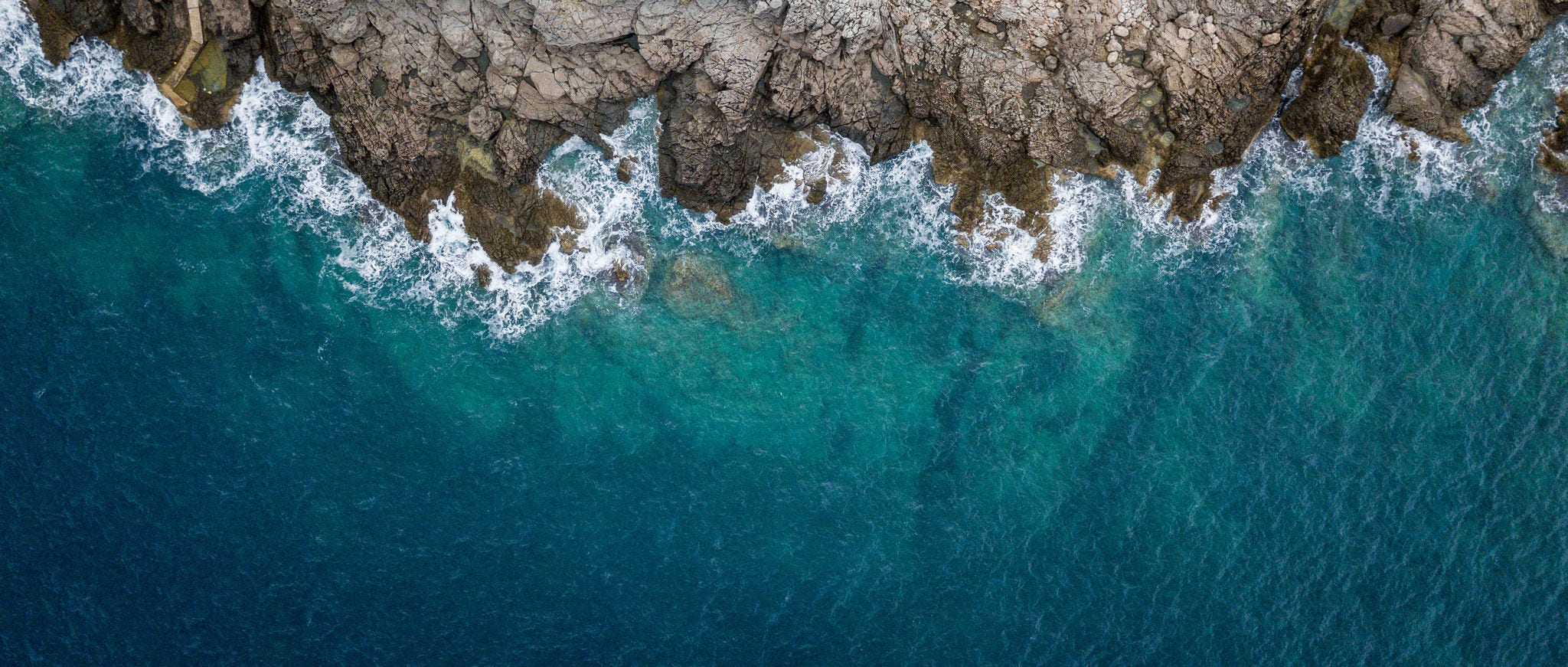 Blue waves crashing on rocky coast 
